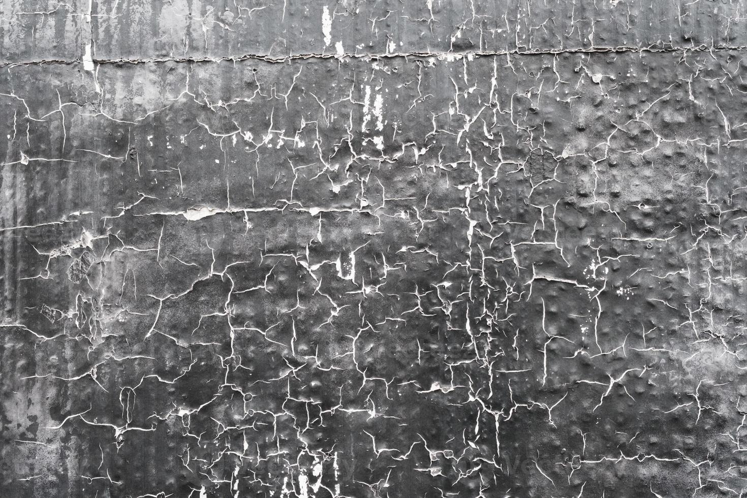 Grey peeling painted wall made of plaster, weathered textured surface, grunge texture background. photo