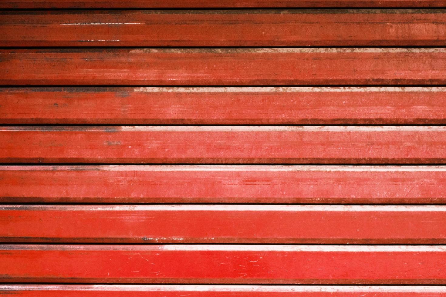 Red metal automatic garage shutter closeup, steel striped sliding door,  texture and pattern, old and weathered surface, dirty grunge background. photo