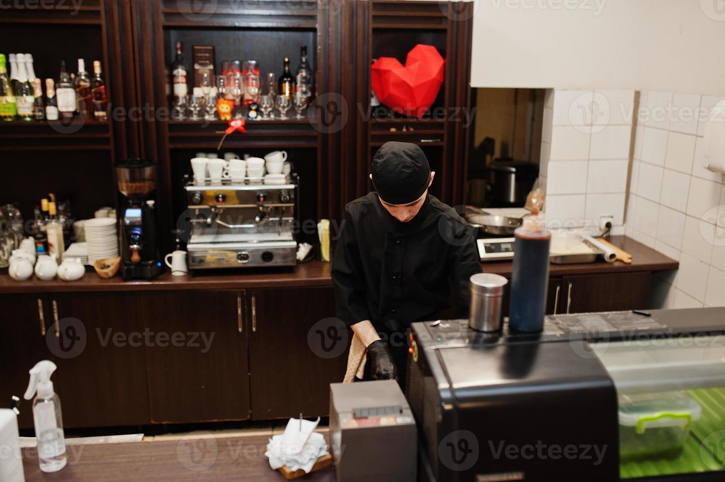 Professional chef wear in black making sushi and rolls in a restaurant kitchen of japanese traditional food. photo