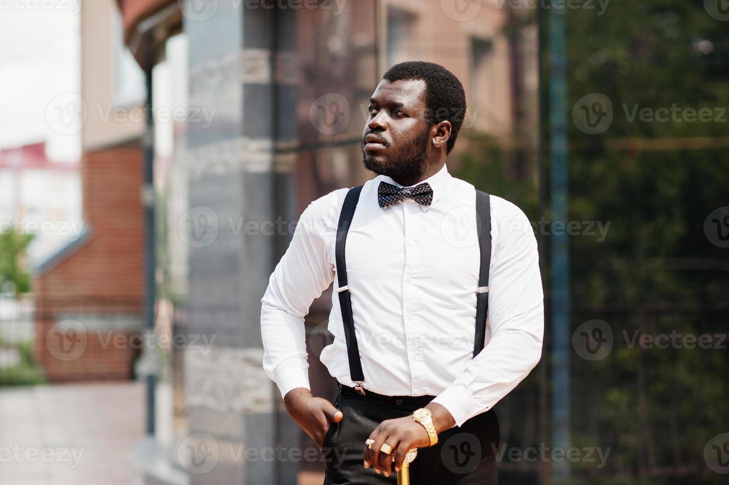 apuesto hombre afroamericano de moda con ropa formal, pajarita y tirantes,  bastón. 10485693 Foto de stock en Vecteezy