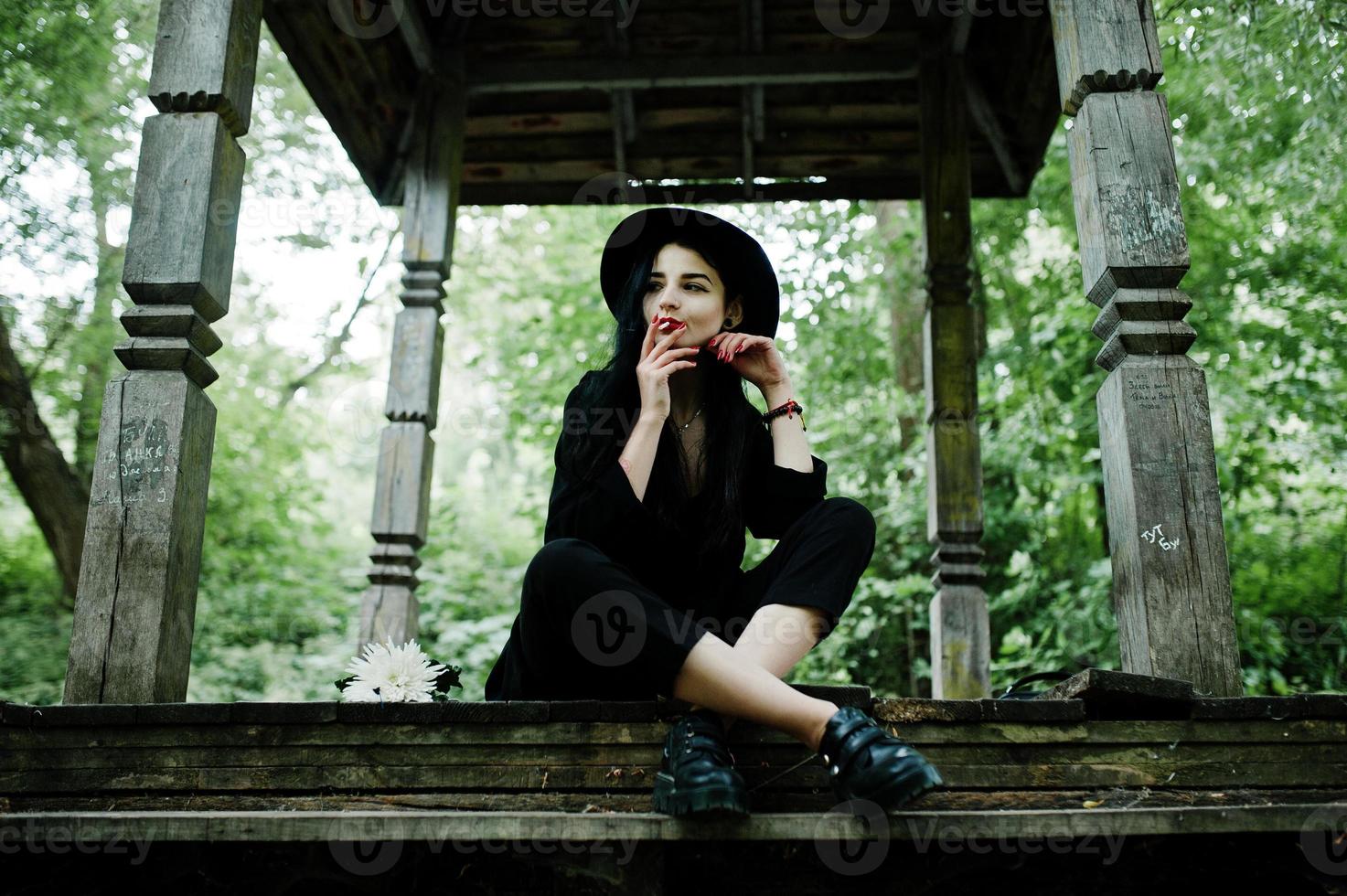 Sensual smoker girl all in black, red lips and hat. Goth dramatic woman smoking thin cigarette. photo