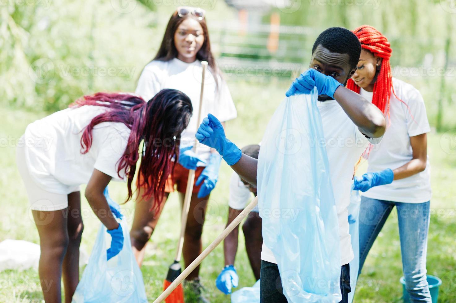 grupo de voluntarios africanos felices con área de limpieza de bolsas de basura en el parque. Concepto de voluntariado, caridad, personas y ecología de África. foto