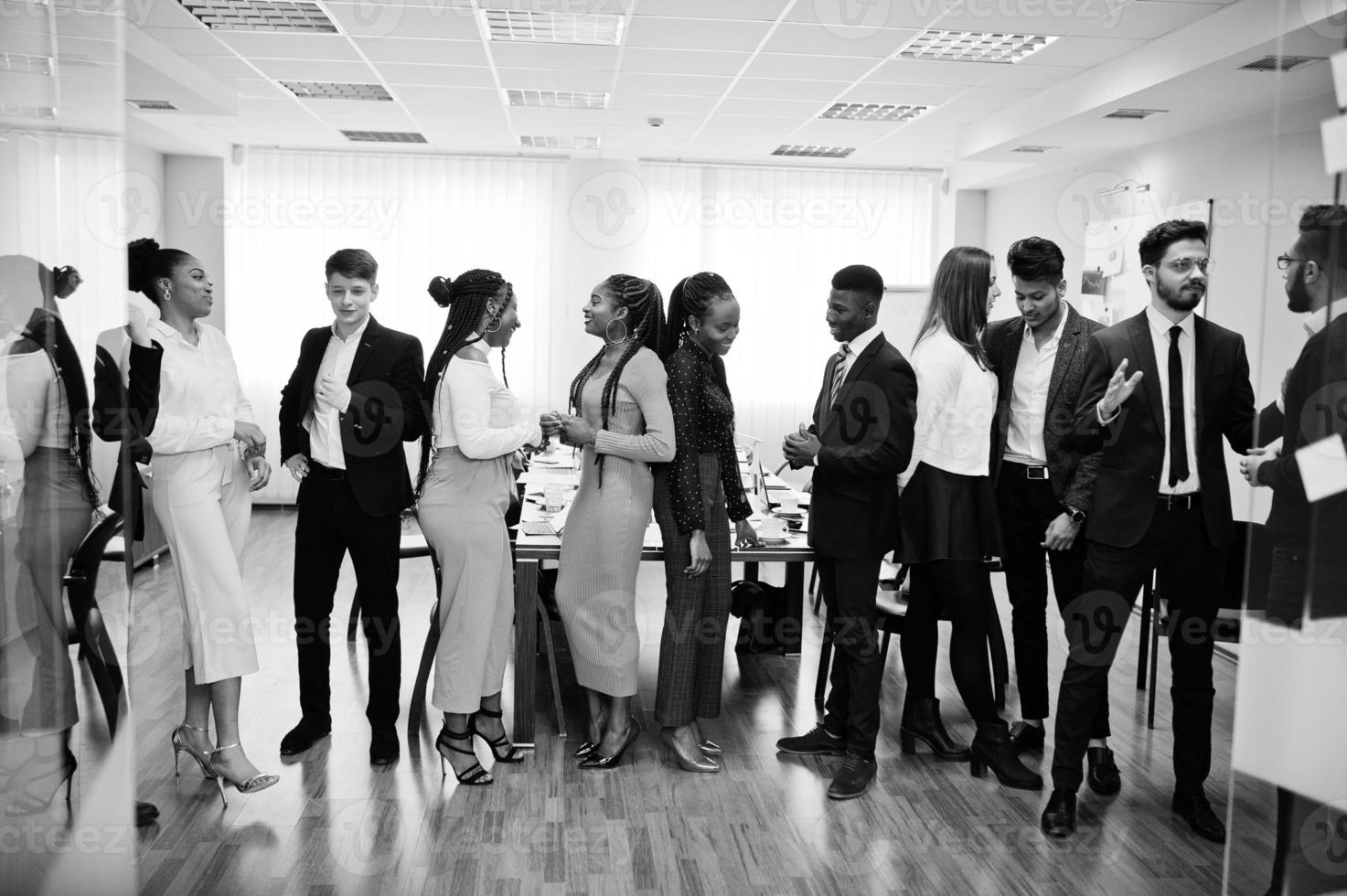 gran grupo de once empresarios multirraciales de pie en la oficina. grupo diverso de empleados en ropa formal. foto