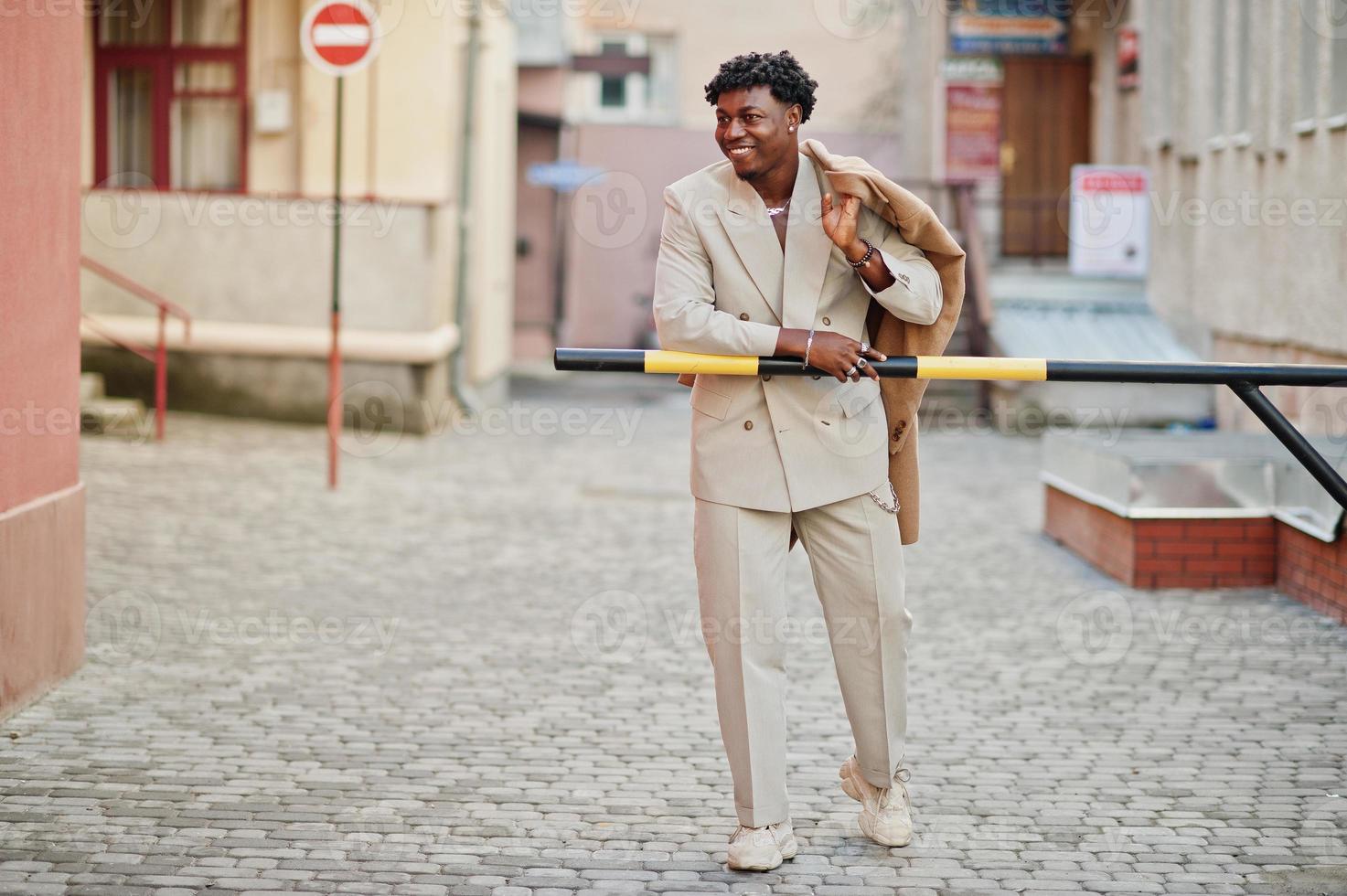 Stylish afro man in beige old school suit. Fashionable young African male in casual jacket on bare torso. photo