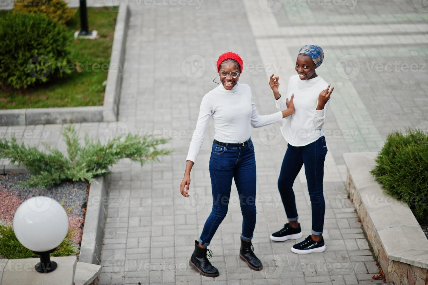 Two young modern fashionable, attractive, tall and slim african muslim womans in hijab or turban head scarf posed together. photo