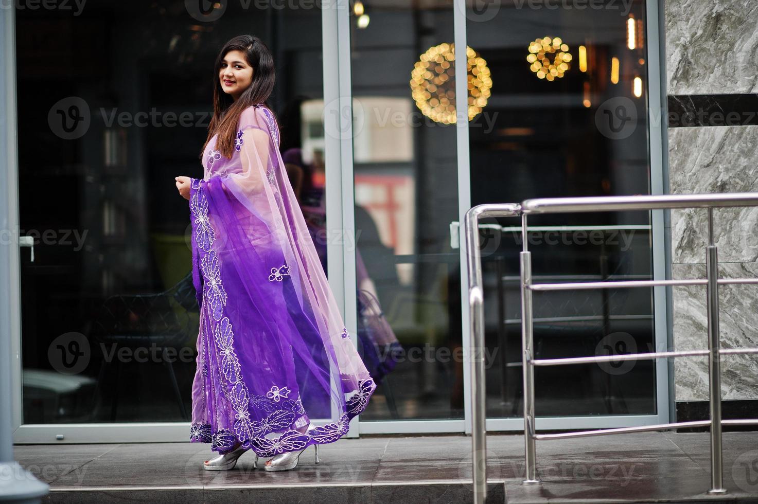 Indian hindu girl at traditional violet saree posed at street. photo