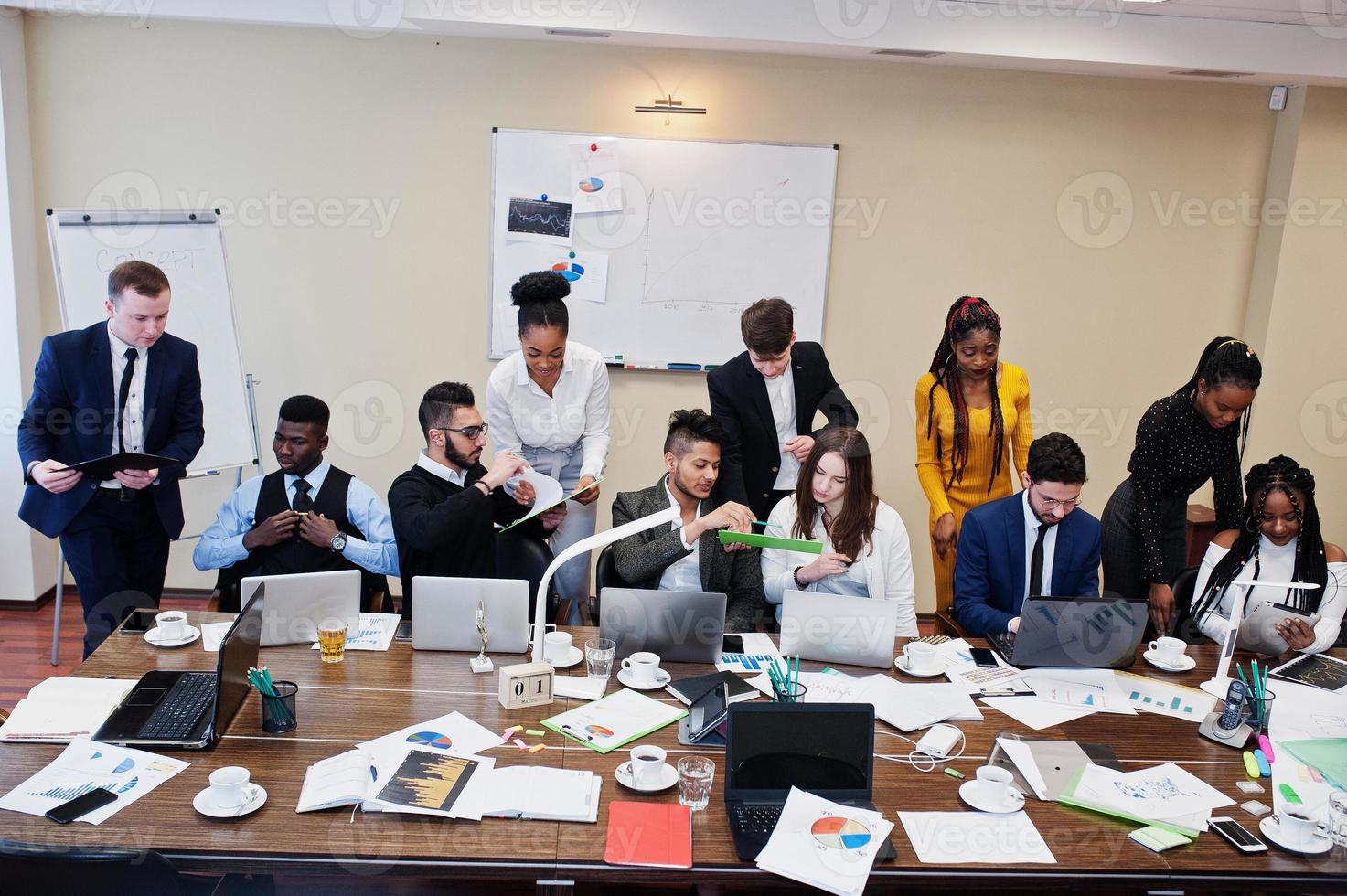 jóvenes creativos multirraciales en la oficina moderna. grupo de jóvenes empresarios están trabajando juntos con laptop, tablet. exitoso equipo de freelancers en coworking. foto
