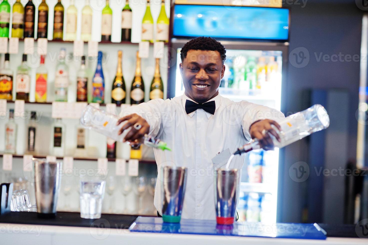 camarero afroamericano trabajando detrás del bar de cócteles. preparación de bebidas alcohólicas. foto