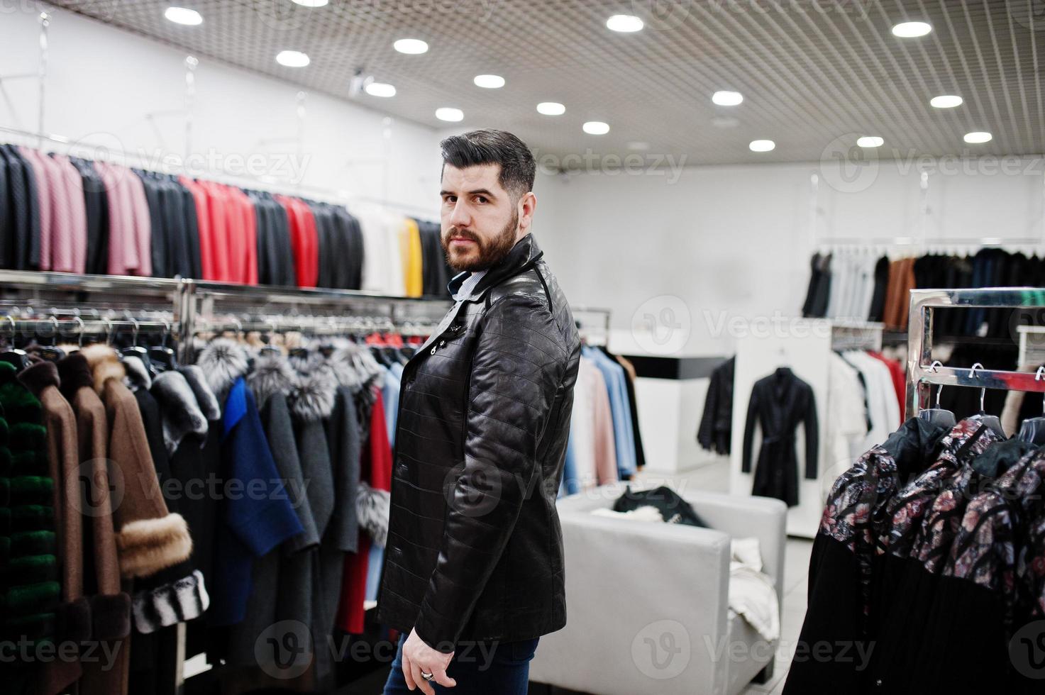 hombre turco con estilo en la tienda de abrigos de piel y chaquetas de cuero. exitoso hombre de barba árabe. foto