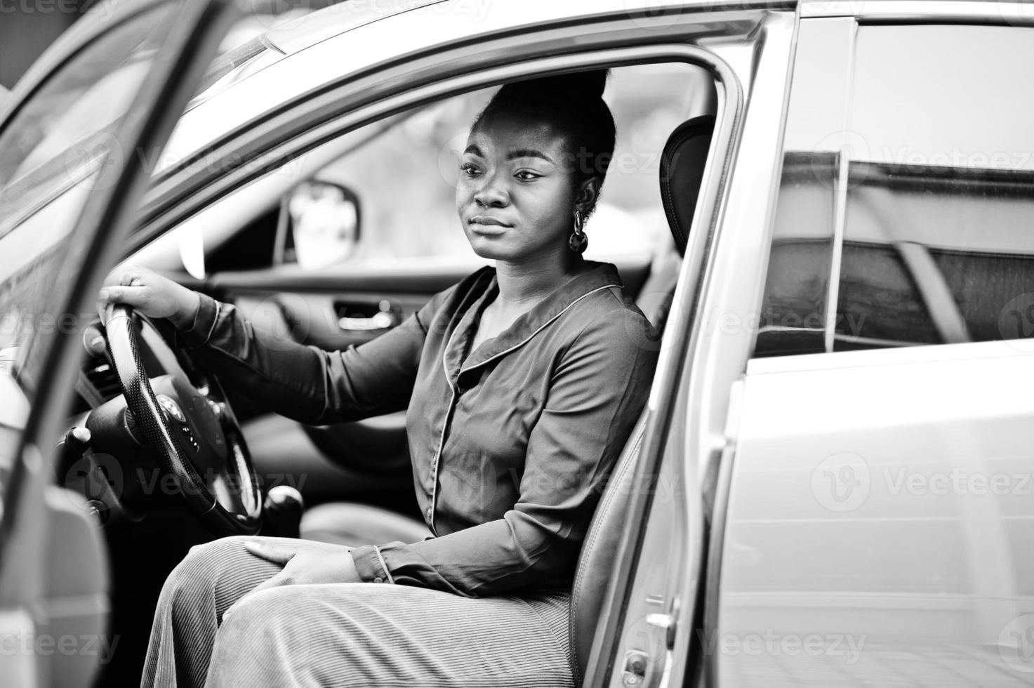 Rich business african woman sit on driver seat at silver suv car with opened door. photo