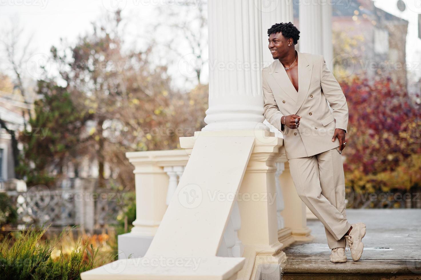 Stylish afro man in beige old school suit. Fashionable young African male in casual jacket on bare torso. photo