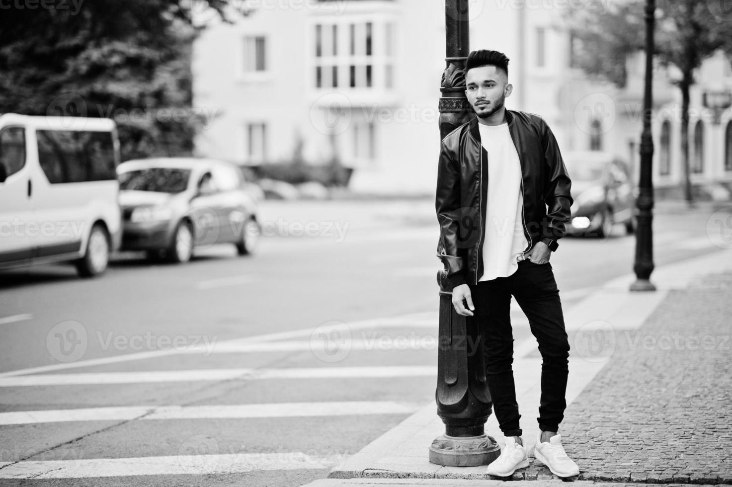 elegante hombre de barba india con chaqueta de cuero negro. modelo india posó al aire libre en las calles de la ciudad. foto