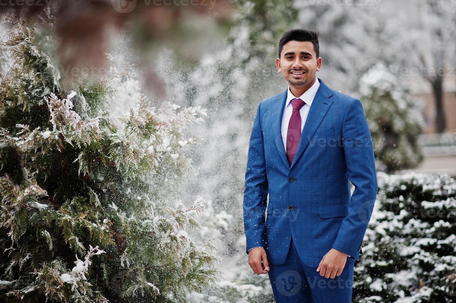 elegante modelo de hombre de moda indio en traje posado en el día de invierno. foto