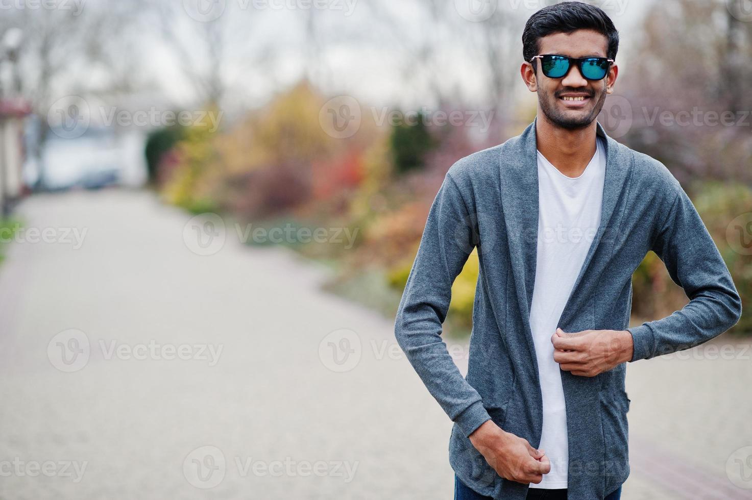 Stylish indian man at sunglasses wear casual posed outdoor. photo