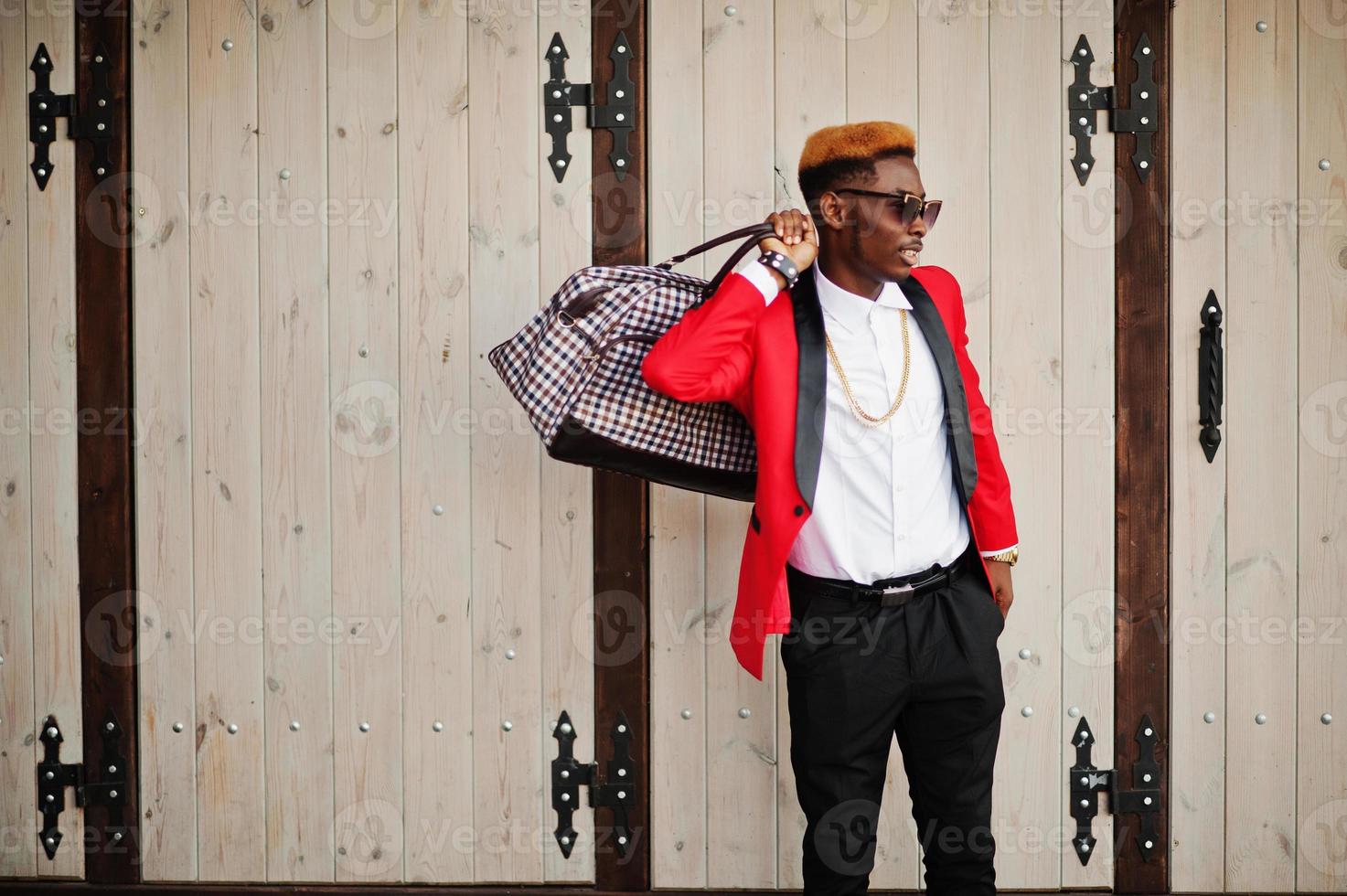 Fashion african american man model at red suit, with highlights hair and handbag posed at street. photo