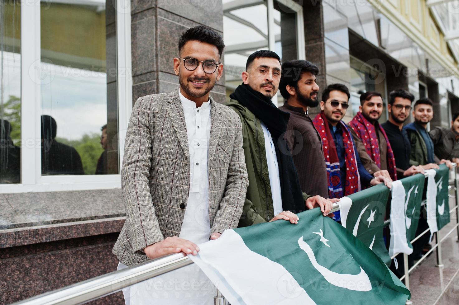 Group of pakistani man wearing traditional clothes salwar kameez or kurta with Pakistan flags. photo