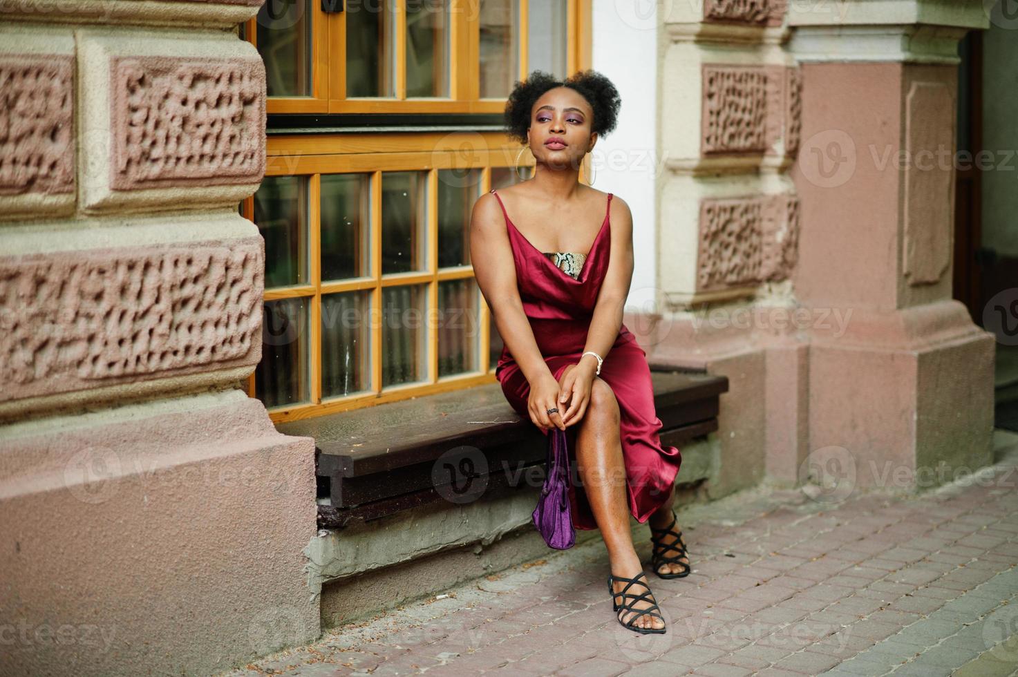 retrato de una hermosa joven africana natural con cabello afro. modelo negro con vestido de seda roja. foto