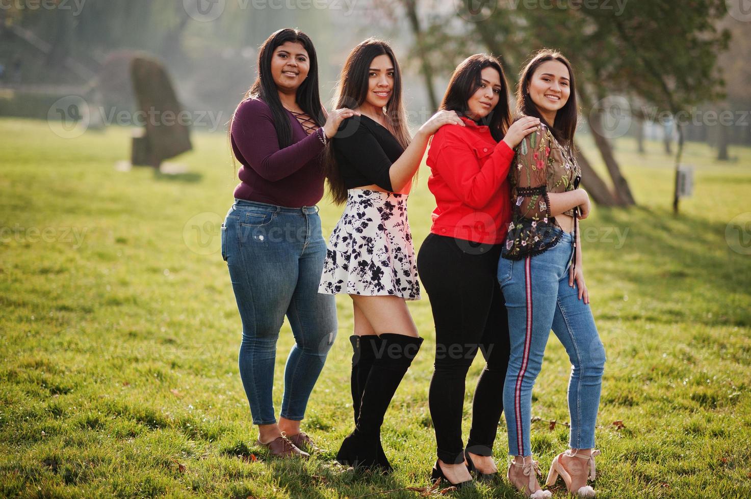 Group of four happy and pretty latino girls from Ecuador posed at street. photo