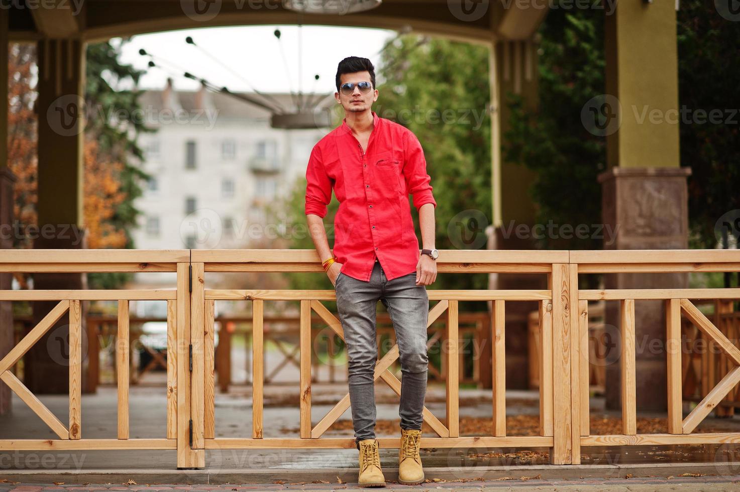 hombre indio con camisa roja y gafas de sol posó al aire libre. foto