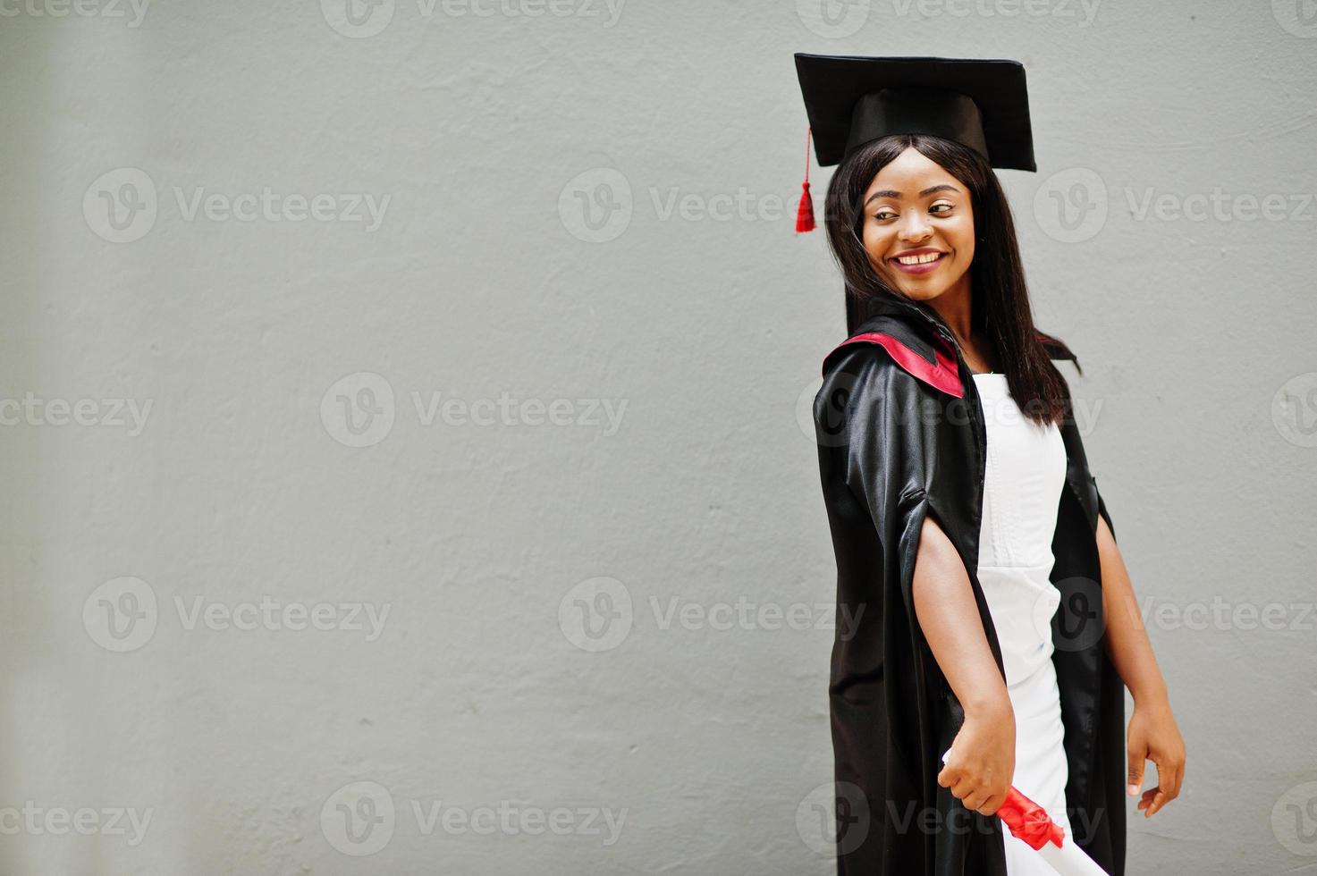 Young female african american student with diploma poses outdoors. photo