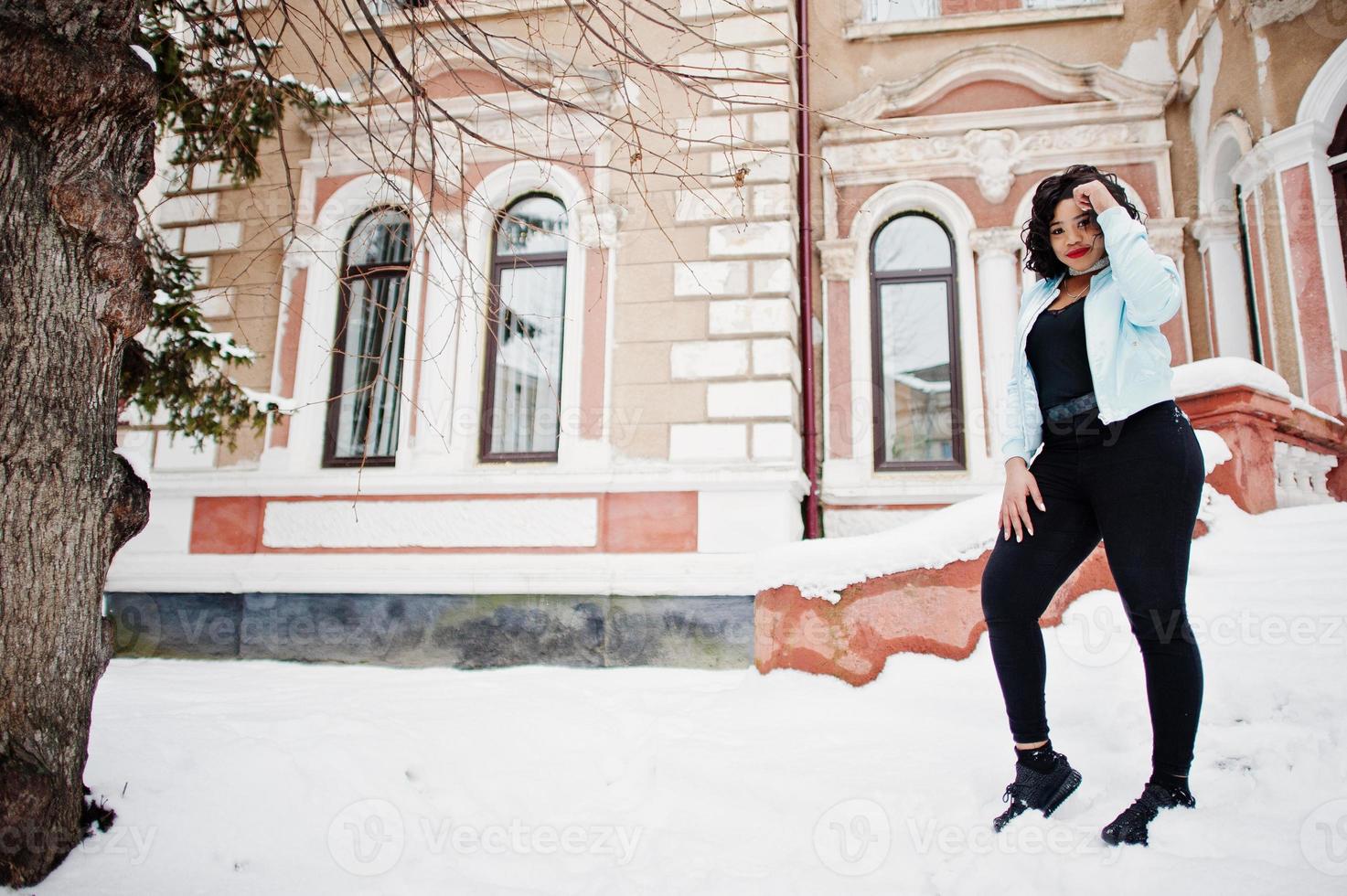 Stylish african american plus size model at streets of city on winter day. photo