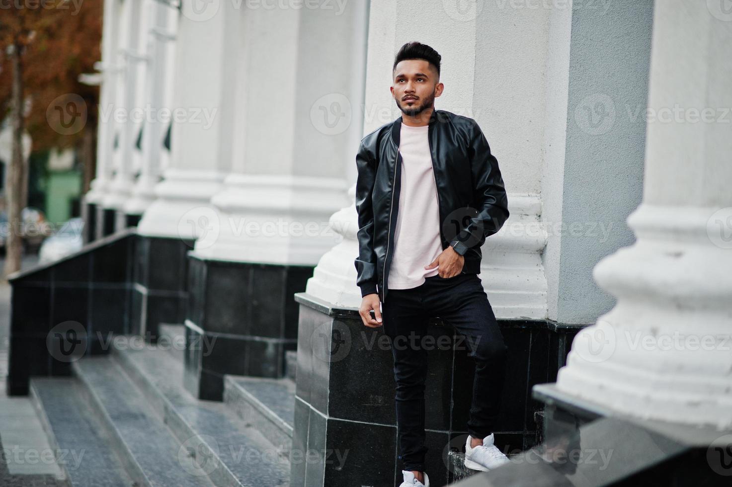 elegante hombre de barba india con chaqueta de cuero negro. modelo india posó al aire libre en las calles de la ciudad. foto