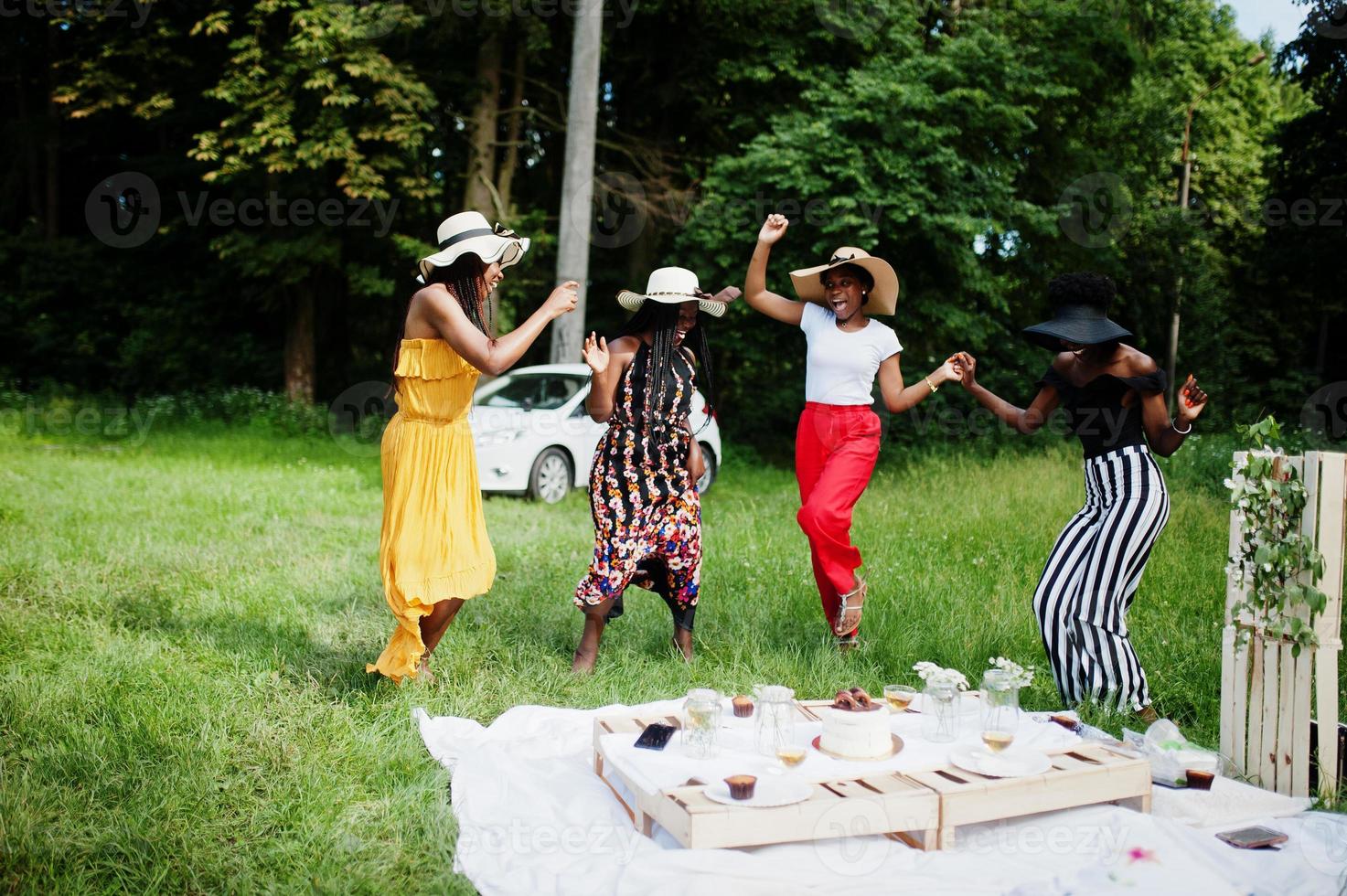 Group of african american girls celebrating birthday party having fun and dancing outdoor with decor. photo