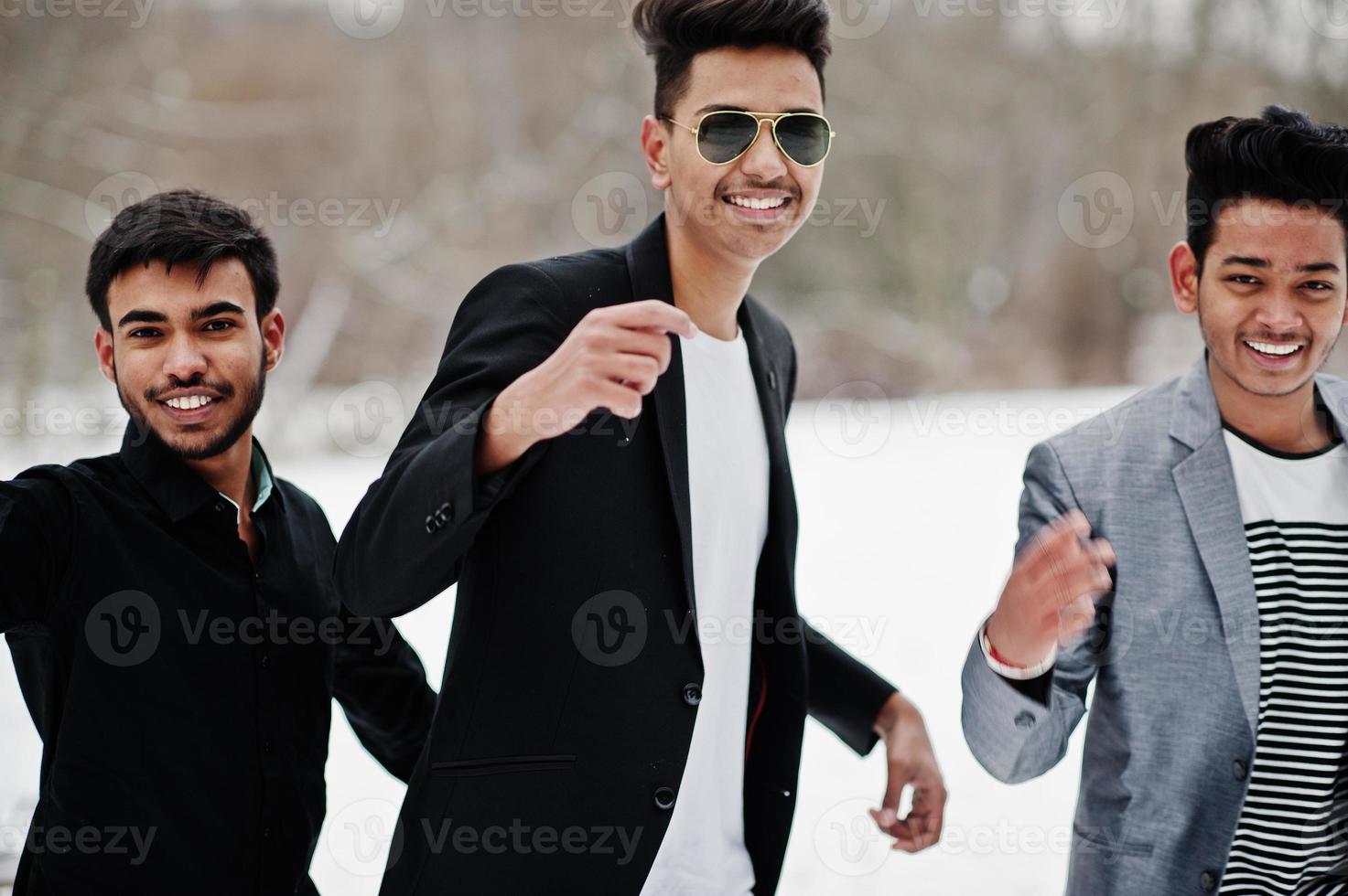 Group of three casual young indian mans posed at winter day having fun and dancing. photo