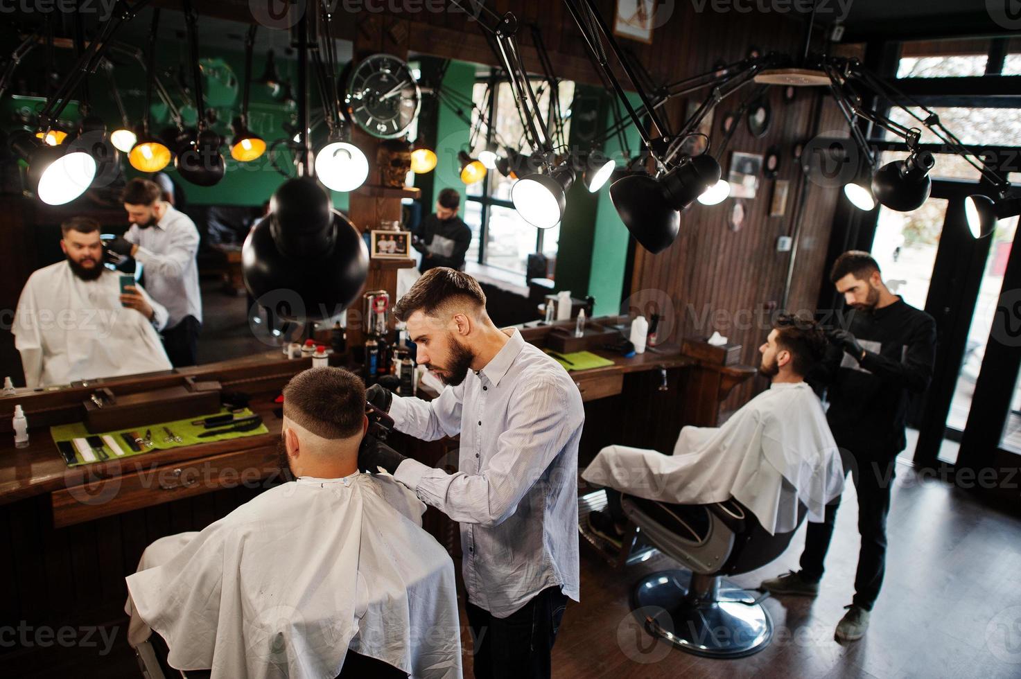 apuesto hombre barbudo en la barbería, peluquero en el trabajo. foto