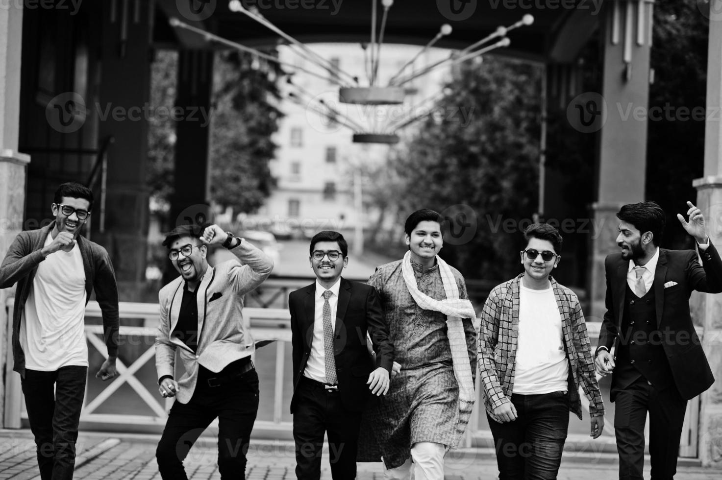 Group of six south asian indian mans in traditional, casual and business wear walking dancing and having fun together. photo