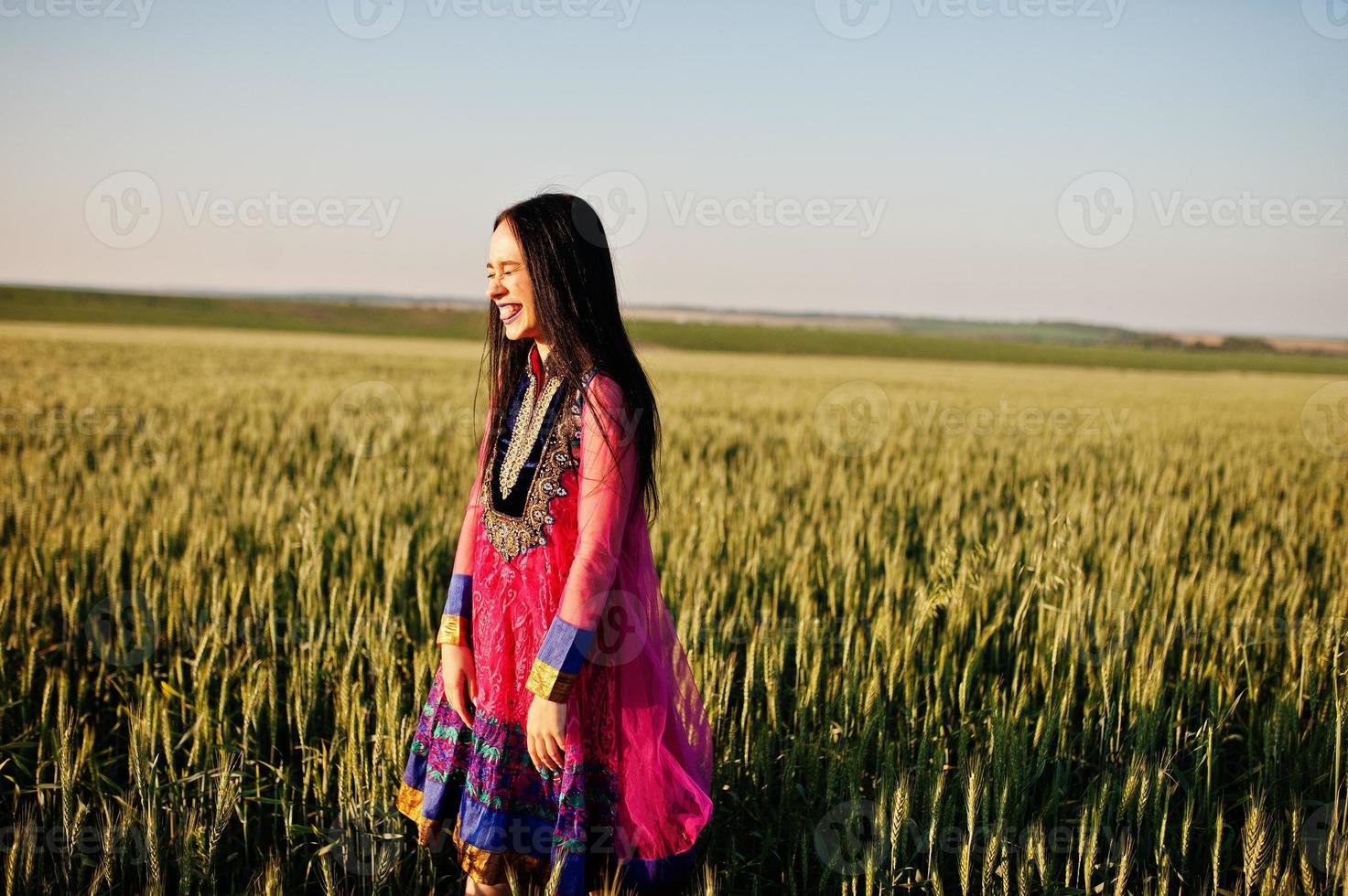 Tender indian girl in saree, with violet lips make up posed at field in sunset. Fashionable india model. photo