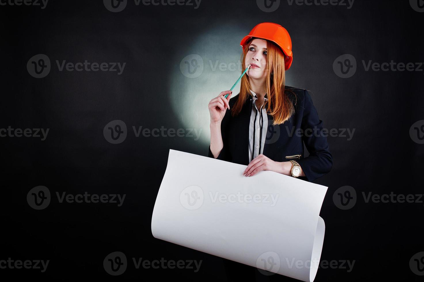 Engineer woman in orange protect helmet with construction paper projekt. photo
