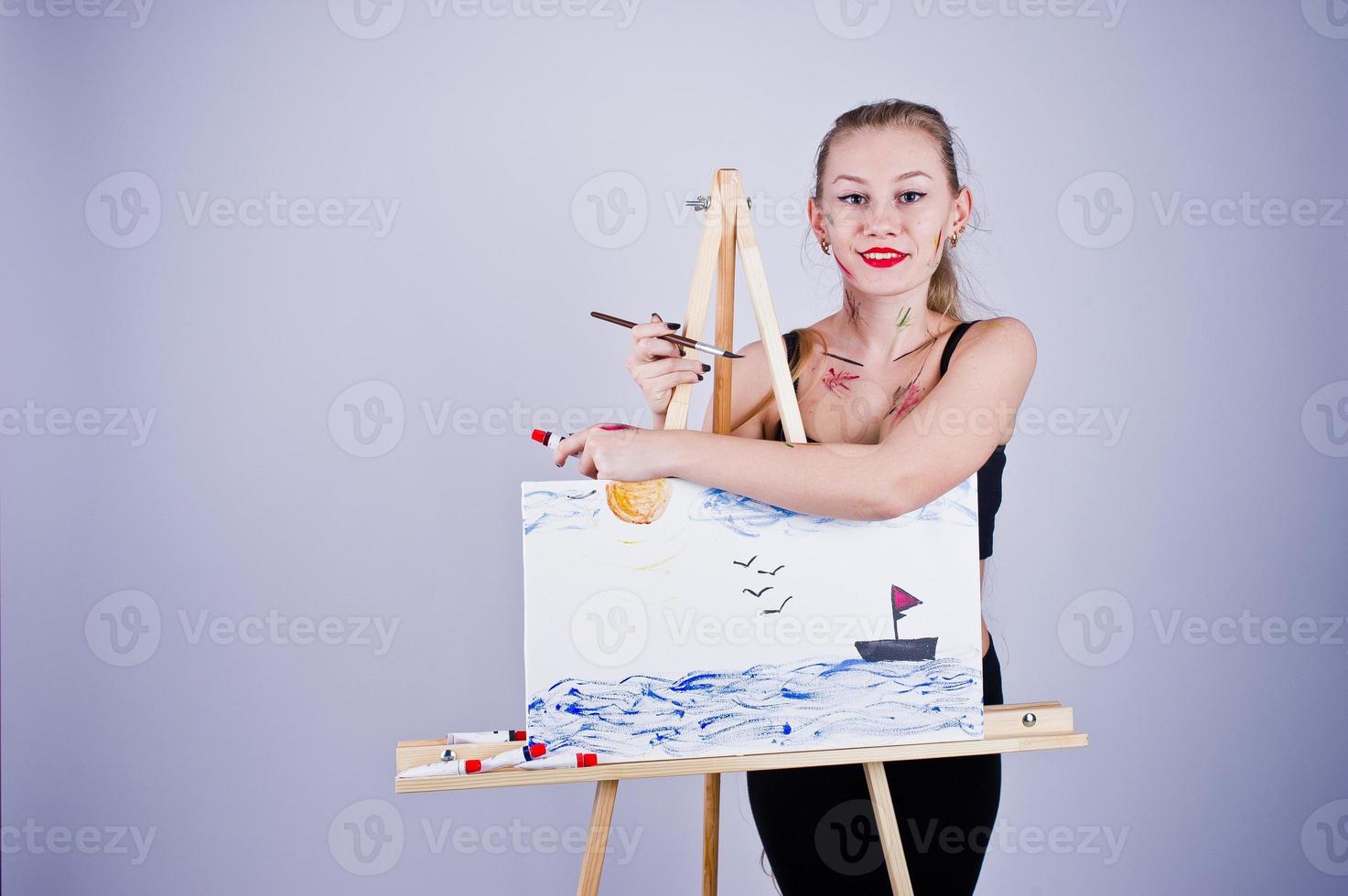 Beautiful woman artist painter with brushes and oil canvas posing in studio isolated on white. photo
