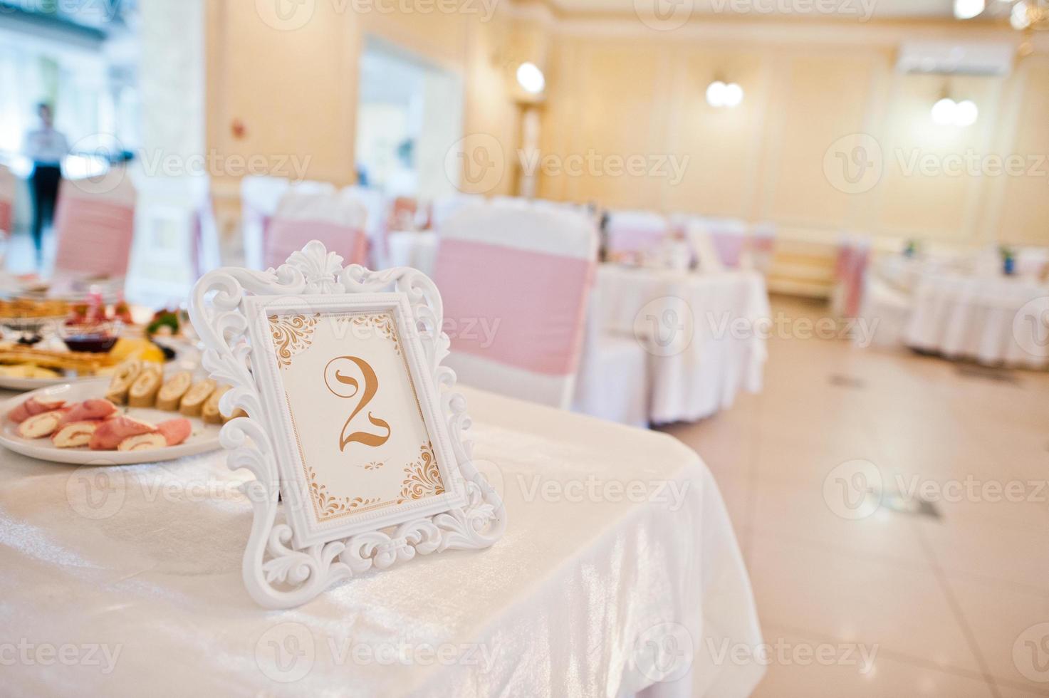 número dos en la mesa de bodas en el restaurante. foto