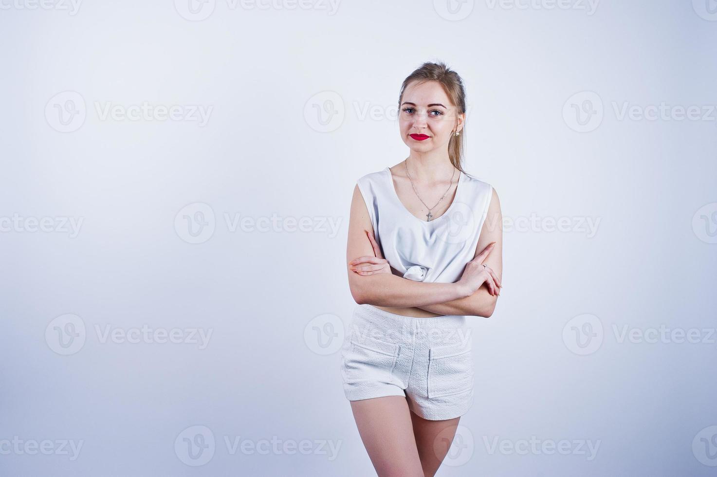 Amazing fit sexy body brunette caucasian girl posing at studio against white background on shorts and top. photo