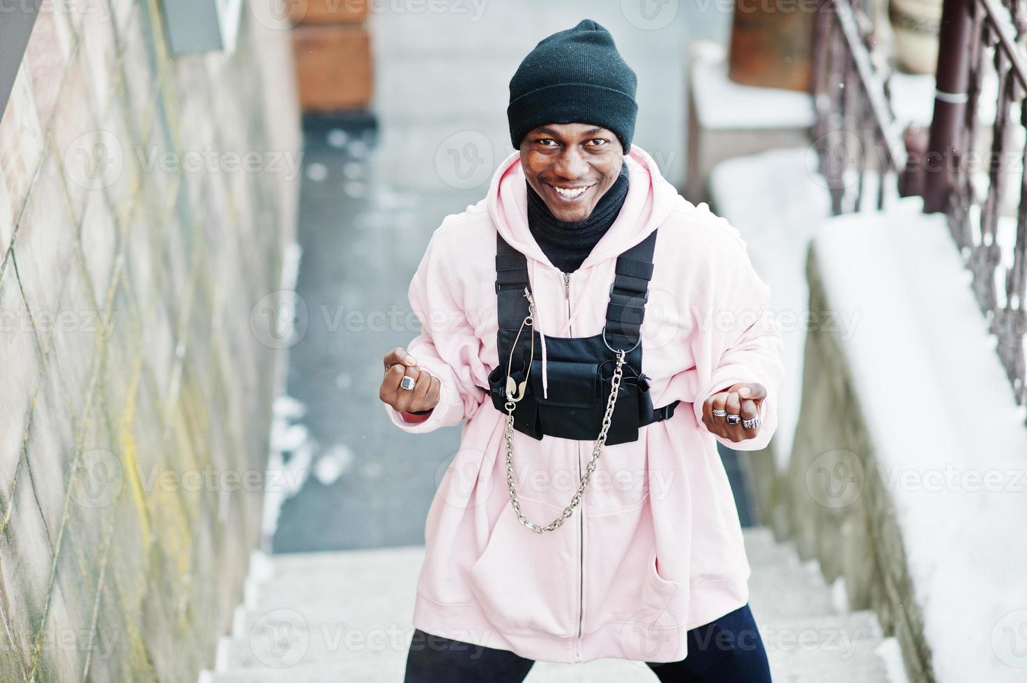 Stylish urban style african american man in pink hoodie posed at winter day and boxing hands. photo
