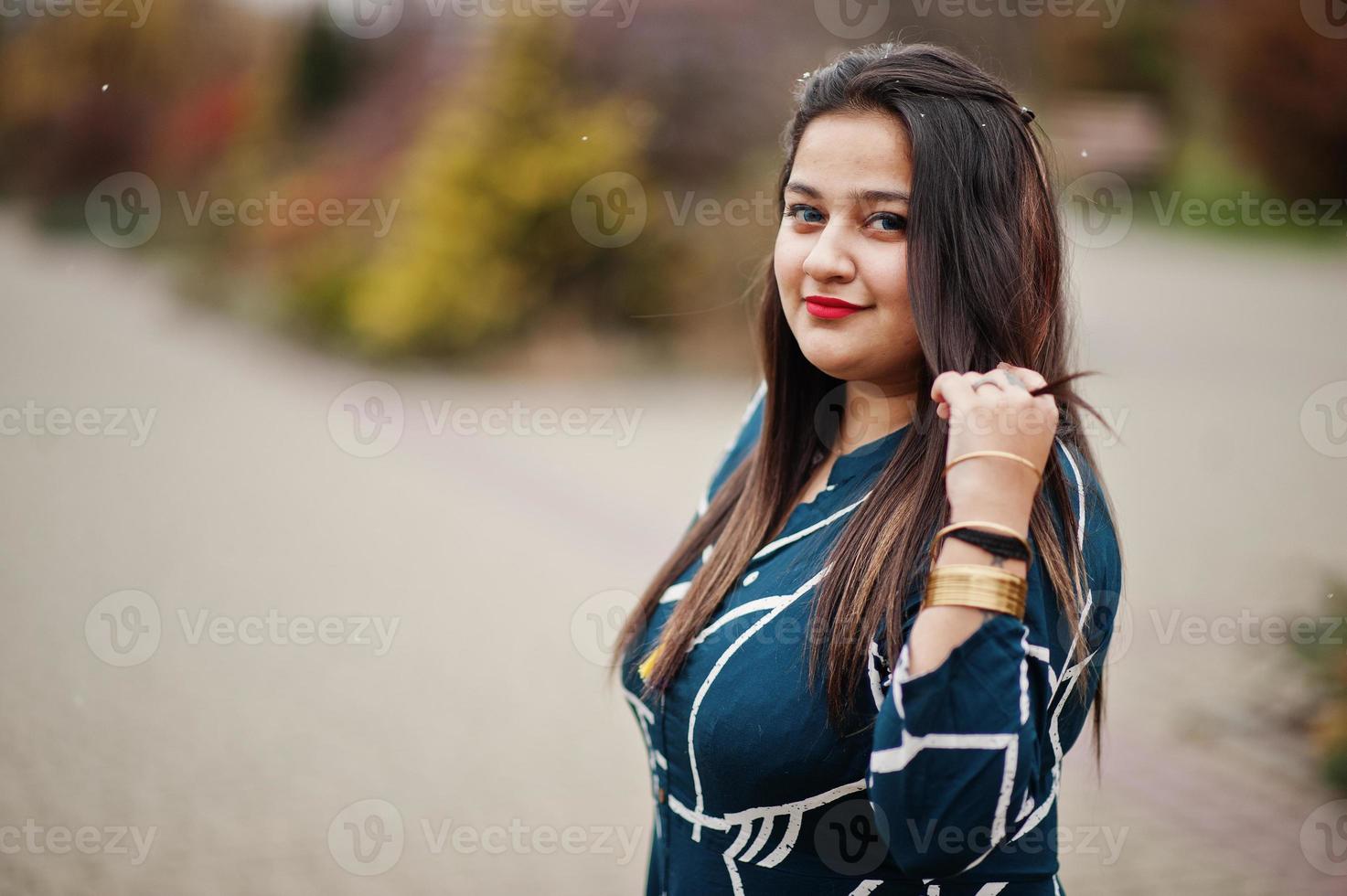 Brunette indian woman in long fashionable dress posed outdoor. photo