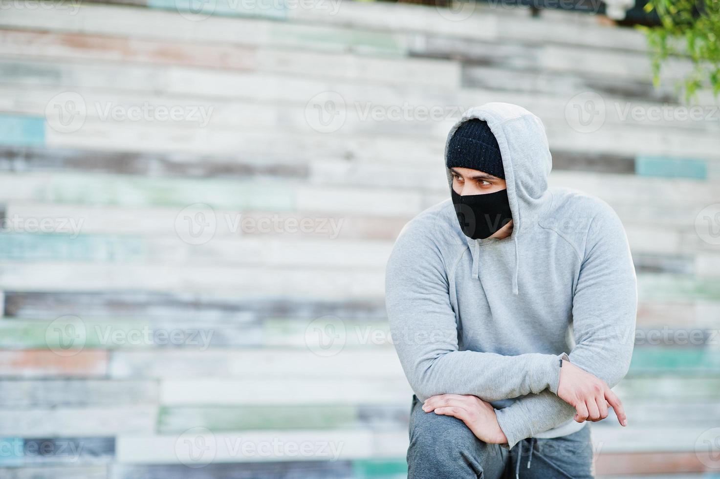 Portrait sports arabian man in black medical face mask and hoodie during coronavirus quarantine. photo