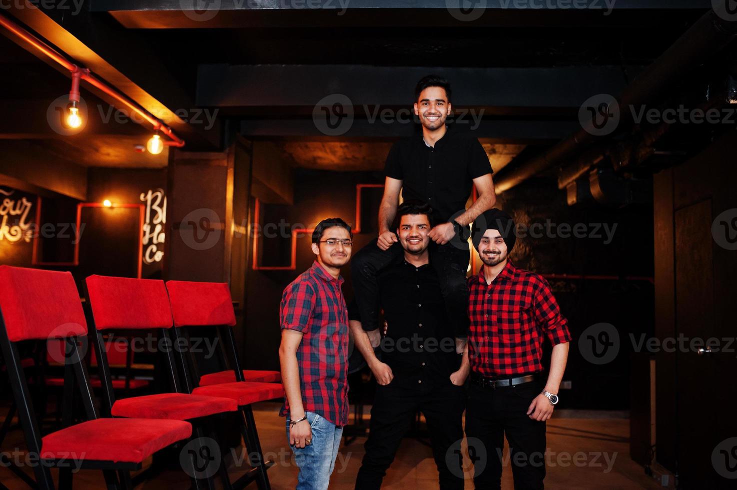Group of indian man friends having fun and rest at night club. photo