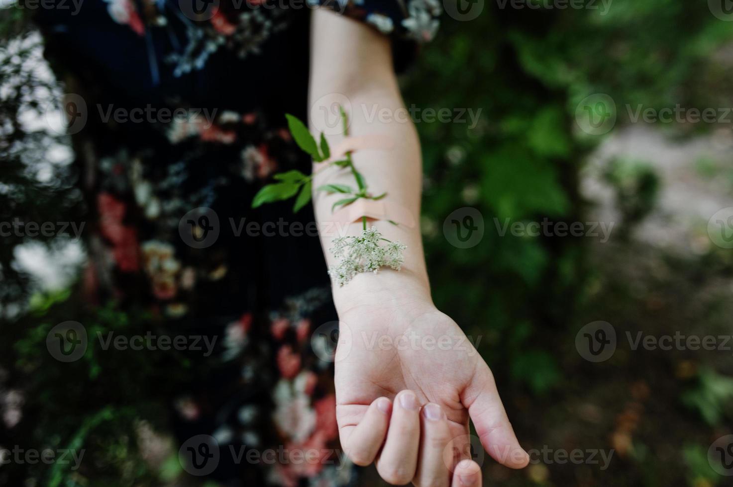 Close-up photo of a flower taped to a female arm.