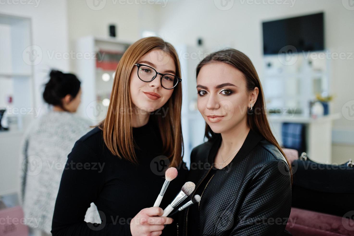 Make up artist work in her beauty visage studio salon. Woman applying by professional make up master. Beauty club concept. photo