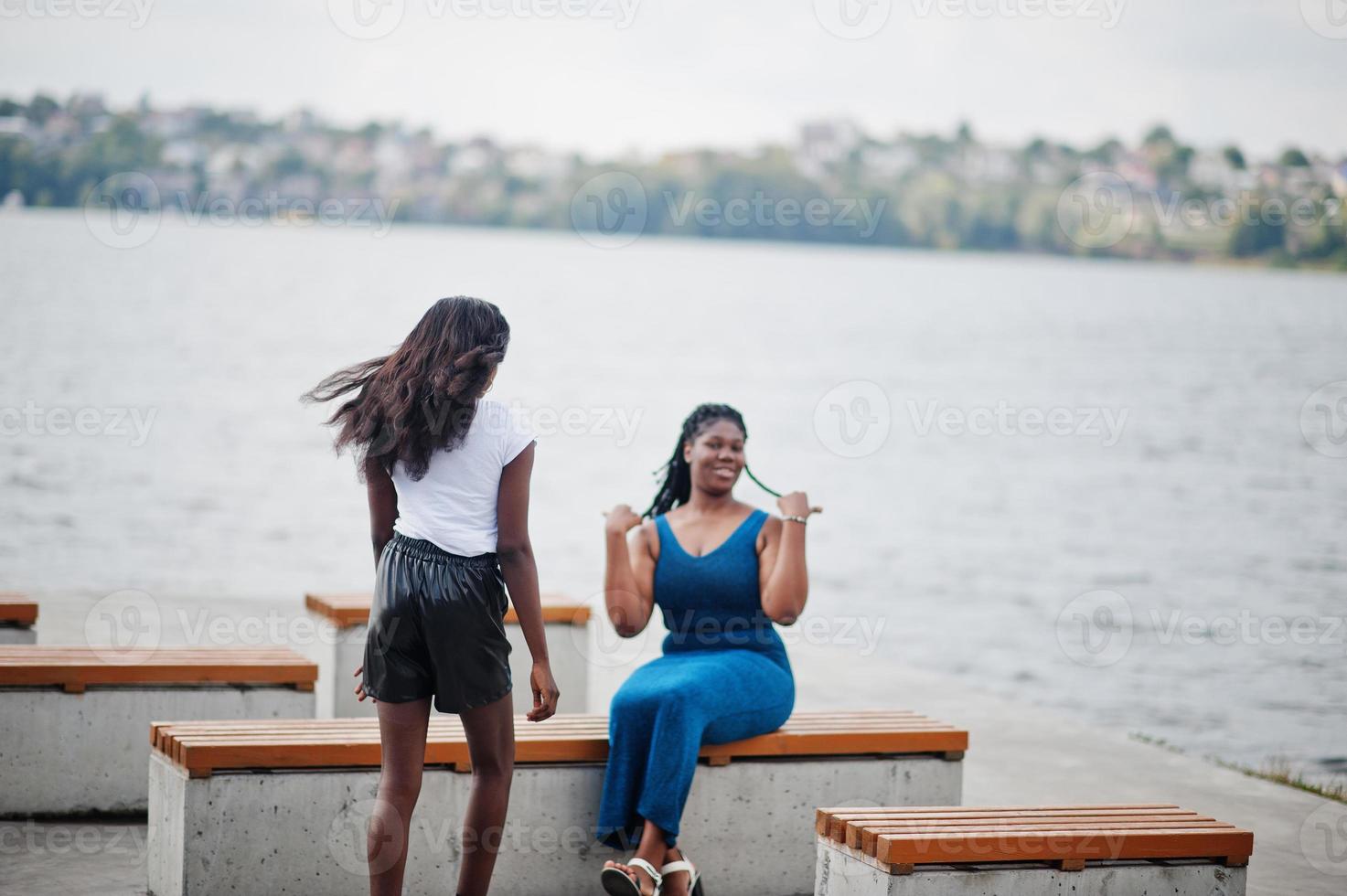 Two african american dark skinned friends female. One of them plus size model, second slim. Having fun and spending time together. photo