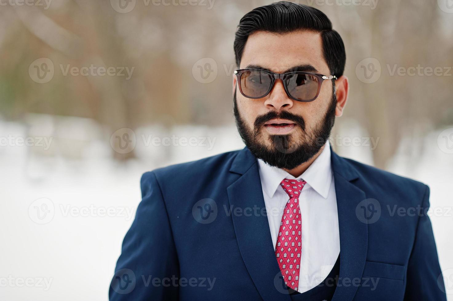 Close up portrait of stylish indian beard business man in suit and sunglasses posed at winter day outdoor. photo