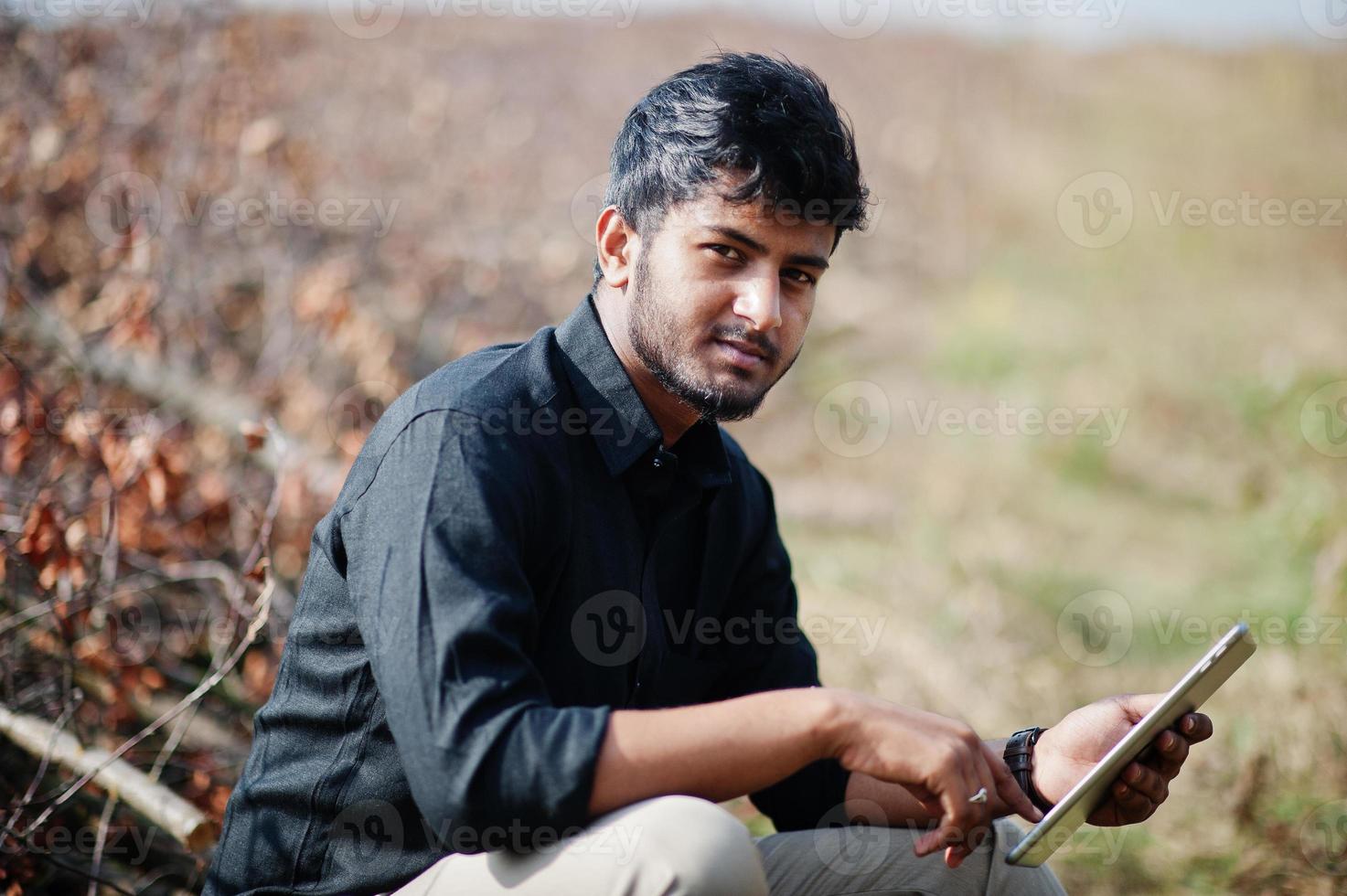 South asian agronomist farmer with clipboard inspecting cut trees in the farm garden. Agriculture production concept. photo