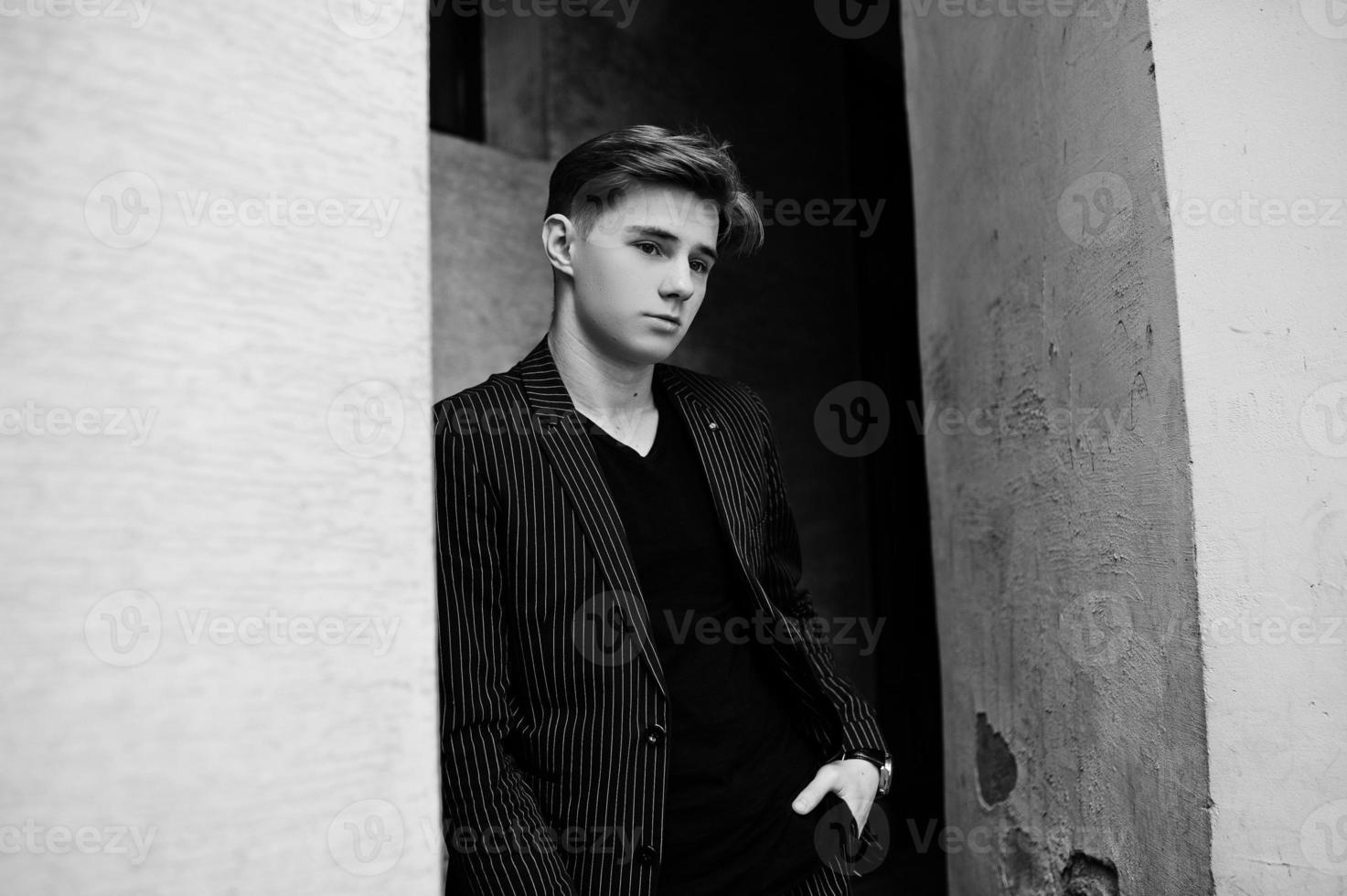 Young stylish macho boy in black jacket posed outdoor of street. Amazing model man. photo