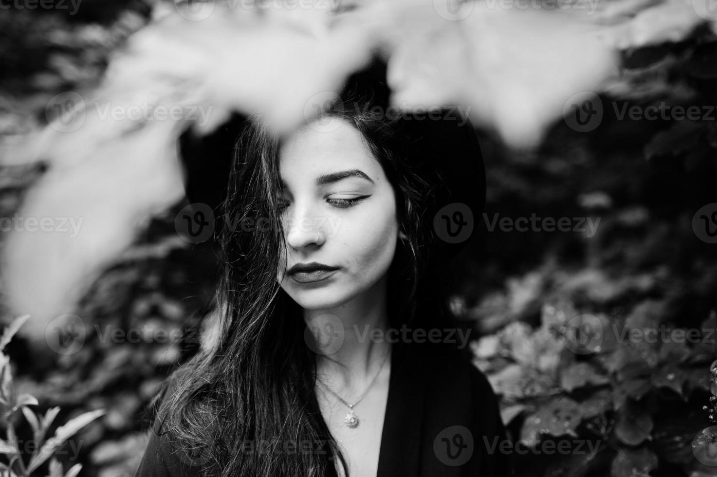 Close up portrait of sensual girl all in black, red lips and hat. Goth dramatic woman. Black and white. photo