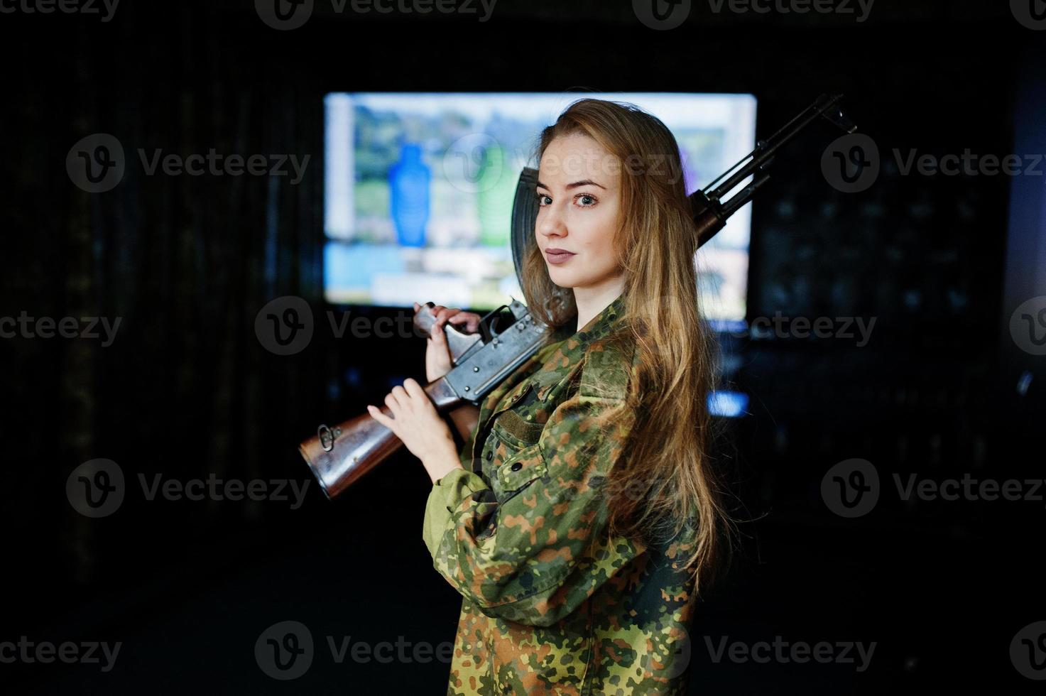 Girl with machine gun at hands on shooting range. photo