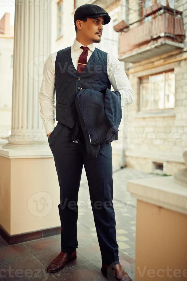 Portrait of retro 1920s english arabian business man wearing dark suit, tie  and flat cap. 10490464 Stock Photo at Vecteezy