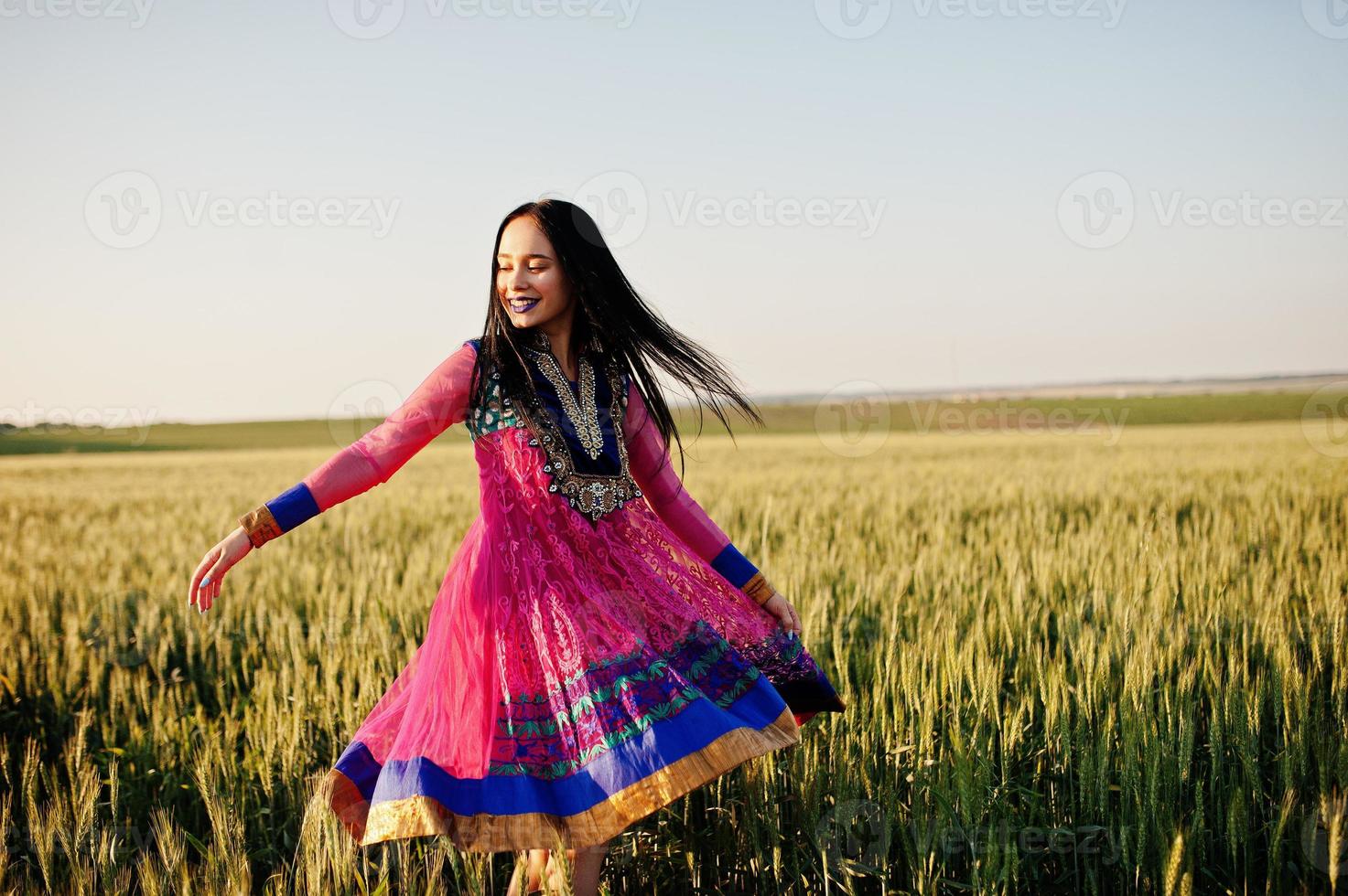Tender indian girl in saree, with violet lips make up posed at field in sunset. Fashionable india model. photo