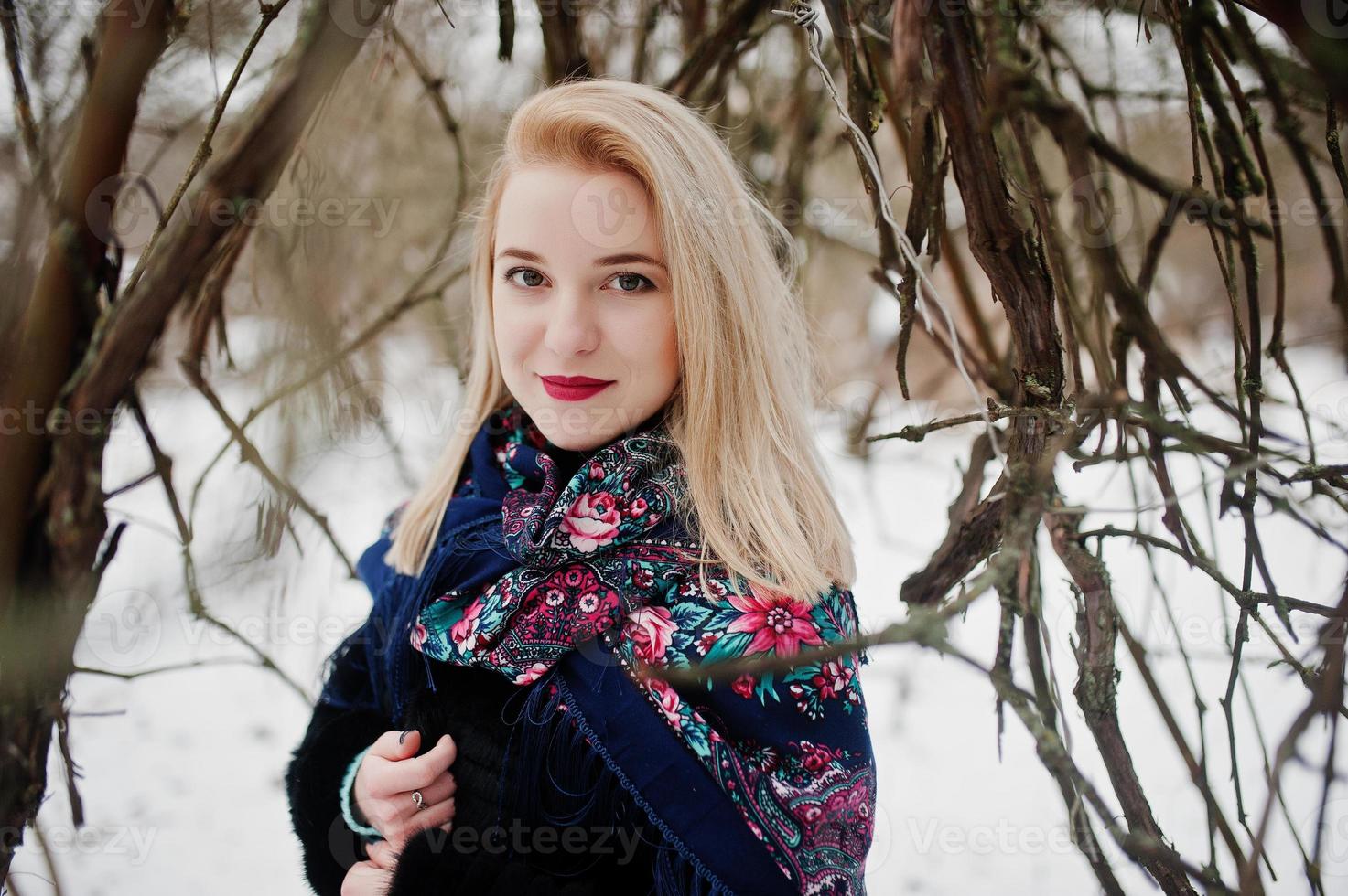 chica rubia con bufanda bordada a mano posada en el día de invierno. pañuelo de mujer. foto